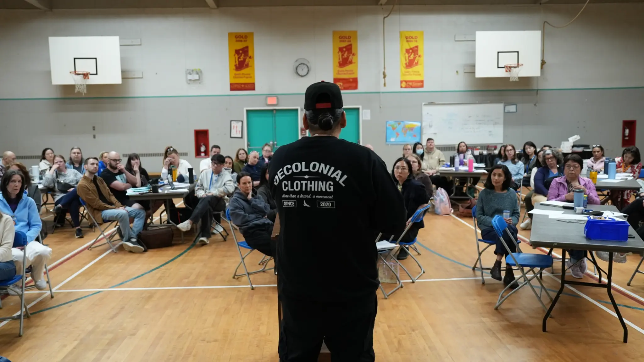 Dakota Bear facing a packed room of school staff